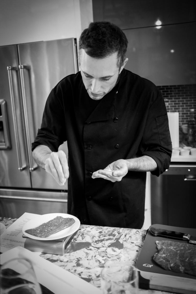 Chef Avi Yadin Sternberg seasoning a fish dish