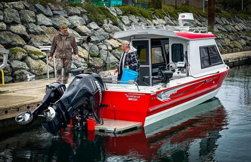 Cute red fishing boat docked at the shore.