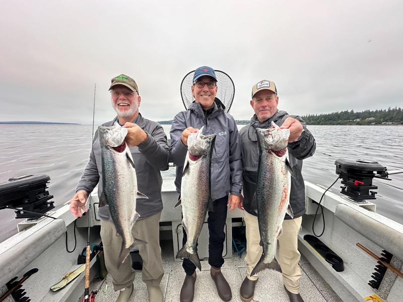 Three fisherman holding their large catches