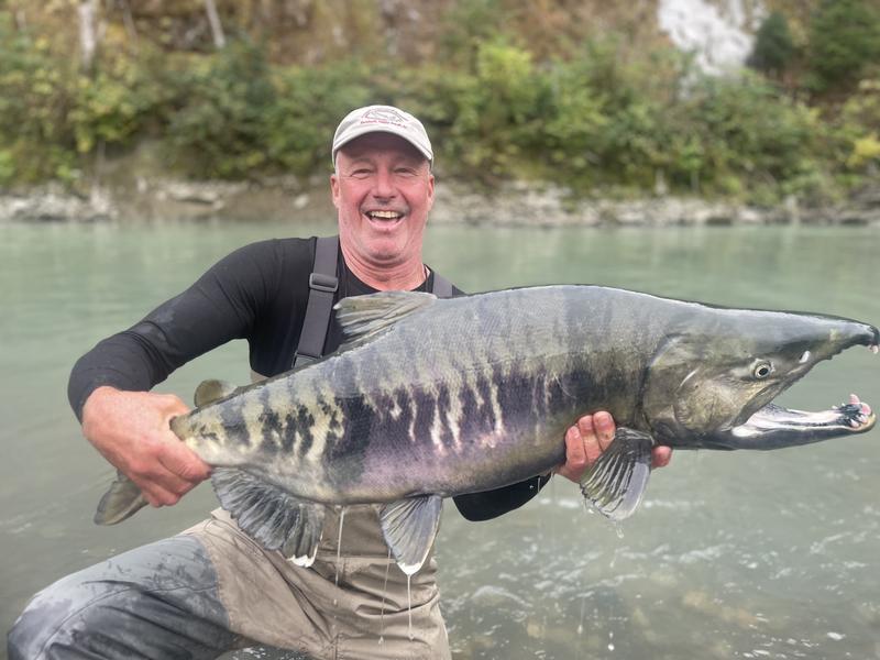 Trophy catch on remote river with a helicopter in the background