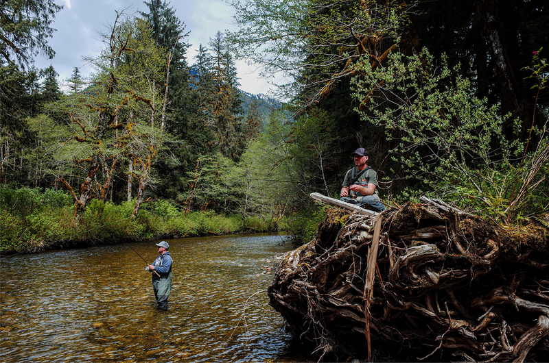 Two men fishing at a stream in the wilderness