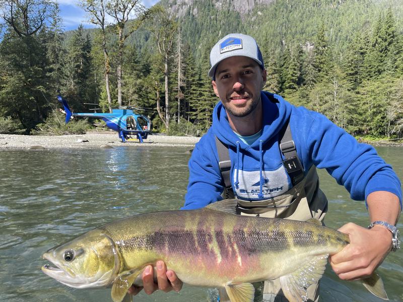 Trophy catch on remote river with a helicopter in the background