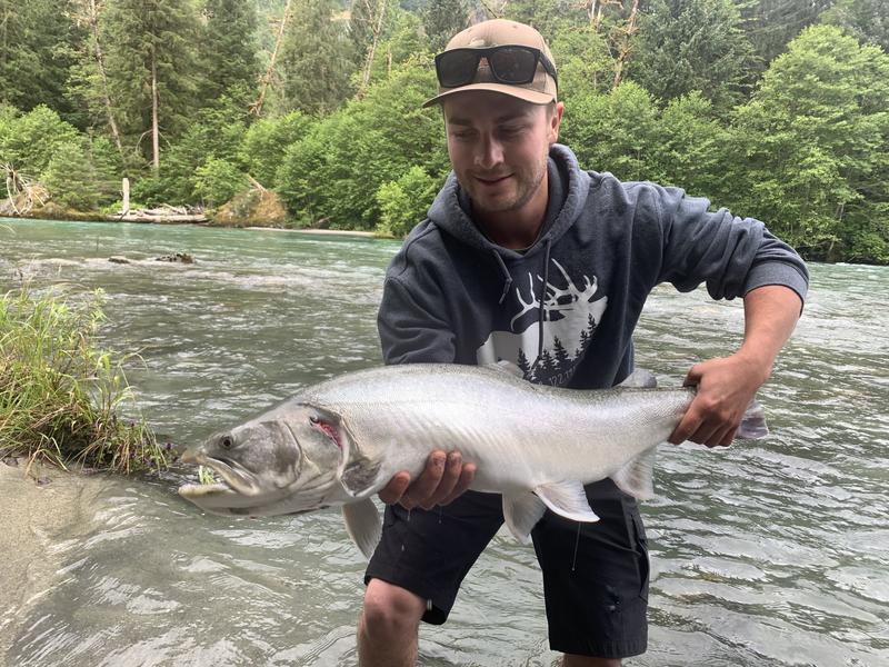 Angler holding a salmon in a river.
