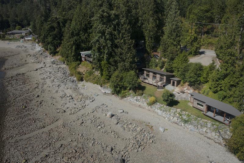 Aerial view of two cabins showing the beach in front and forest behind