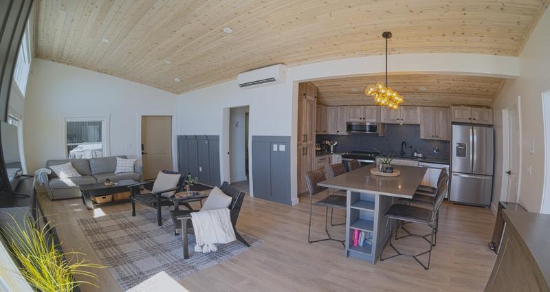 Cozy modern interior of cabin with kitchen, table, and sofa