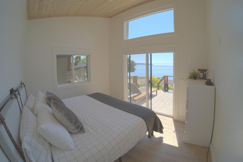 Bed with view of ocean through glass door